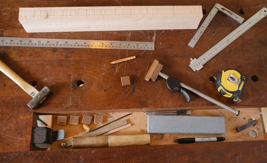 A marking gauge scribing a line on the edge of a board