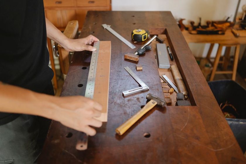 A drafting table with a technical drawing of a furniture joint, ruler, and pencil